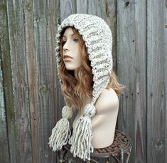 "Style: Bonnet style hood with fluffy oversized tassels. Color: This sample hat is shown in Oatmeal. You can choose from 34 colors. Please see the last photo in the listing and zoom in for a visual reference of your color choices, then select it from the drop down menu when ordering. Sizes: One size fits 20\" to 23\" (50.5 cm to 58 cm) head size. Fiber Content: 80% acrylic, 20% Wool Characteristics: Whimsical, very soft, warm and cozy. Care Instructions: Hand wash, dry flat. Every item from Pixi Crochet Baby Cap, Chunky Crochet Hat, Crochet Hood, Women's Mittens, Flap Hat, Earflap Hat, Ear Flap Hats, Pixie Hat, Bonnet Crochet