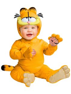 a baby in a yellow tiger costume sitting on the floor with his hands up and mouth wide open