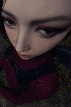 an animated woman with black hair and blue eyes wearing a red sweater looking at the camera