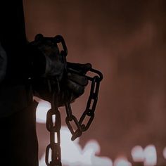 a hand holding a chain in the dark