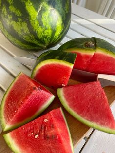 slices of watermelon on a cutting board next to a knife