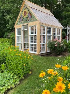 a small garden shed in the middle of some flowers