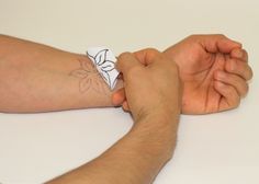 a man with a tattoo on his arm is holding another mans hand over the table