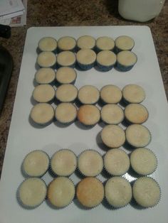 a number made out of cupcakes sitting on top of a white cutting board