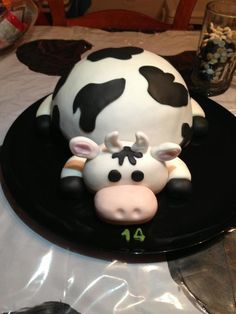 a cake shaped like a cow on top of a black plate