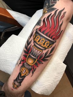 a man with a tattoo on his arm has a torch in the middle of it