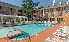 an outdoor swimming pool surrounded by lawn chairs