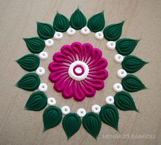 a colorful flower with green leaves and white centers on a wooden surface, surrounded by beads