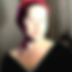 a blurry image of a woman with a red hat on her head and neck