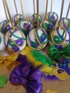 there are many mardi gras cake pops on the table next to each other