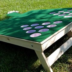 an outdoor game set up in the grass with purple dots on it and white balls scattered about