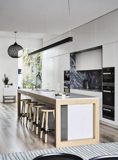 a kitchen with an island and stools in it