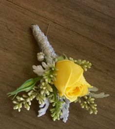 a yellow rose and some white flowers on a table