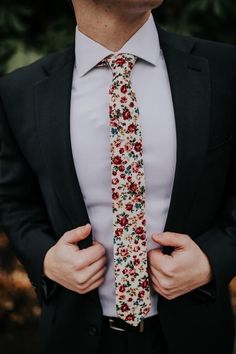 a man wearing a suit and tie with flowers on it