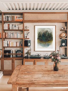 a wooden table sitting in front of a book shelf filled with books