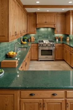 a kitchen with green counter tops and wooden cabinets in the center, along with a silver stove top oven