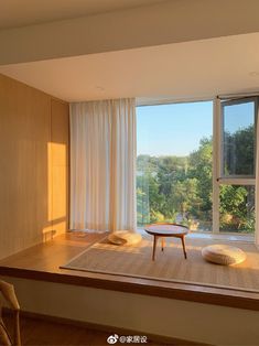 a living room with a large window overlooking the trees