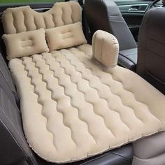 an inflatable car bed is sitting on the back seat of a car,