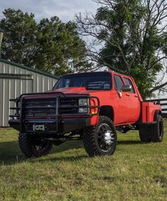 a red truck is parked in the grass