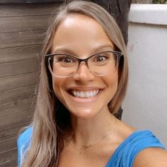 a woman wearing glasses and smiling for the camera