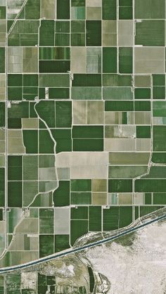 an aerial view of the countryside in green and brown colors, with roads running through it