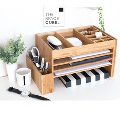 a wooden desk organizer with office supplies in it and the space cube logo above it