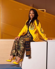 a woman sitting on top of a white box next to a blue stool and yellow wall