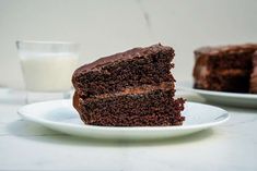 a piece of chocolate cake on a plate next to a glass of milk