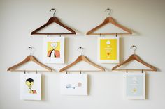 clothes hangers are hung on the wall with pictures