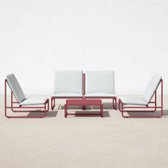 three lounge chairs sitting next to each other in front of a white wall and cement floor