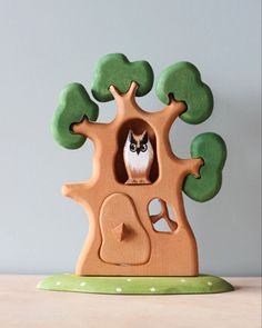 a wooden toy tree with an owl in it