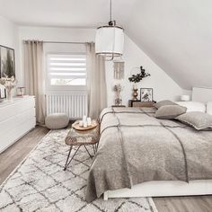 a bedroom with a bed, dresser and window in the corner is decorated in neutral colors