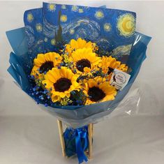 a bouquet of sunflowers wrapped in blue and yellow paper with a starr background