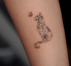 a cat tattoo on the arm with flowers and butterflies in it's back legs