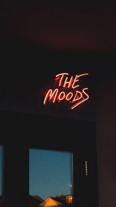 a neon sign that reads the moods above two windows