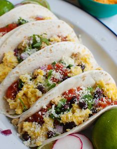 breakfast tacos on a plate with limes