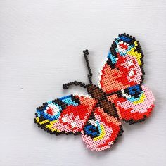 a beaded butterfly is shown on a white surface