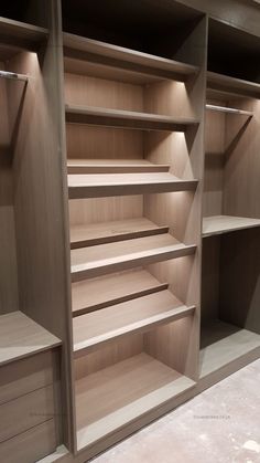 an empty walk in closet with wooden shelves