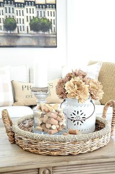 a basket filled with flowers sitting on top of a wooden table next to a couch