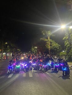 a group of motorcyclists are parked on the side of the road at night