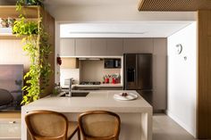 two chairs are sitting at the counter in this modern kitchen