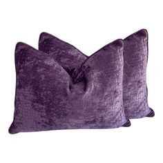 two purple velvet pillows sitting on top of each other