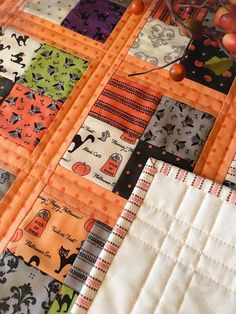 an orange and black patchwork quilt with pumpkins on it