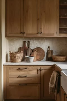 a kitchen with wooden cabinets and baskets on the counter top, along with other utensils