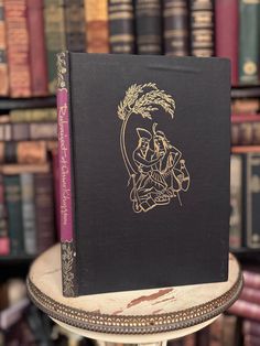 a book sitting on top of a table in front of a bookshelf filled with books