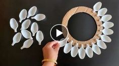 someone is making a wreath out of plastic spoons and paper leaves on the table