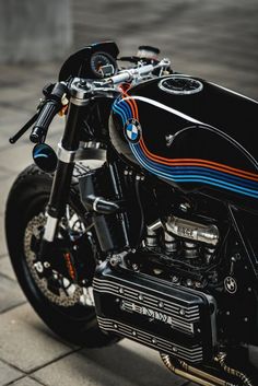 a black motorcycle parked on top of a sidewalk