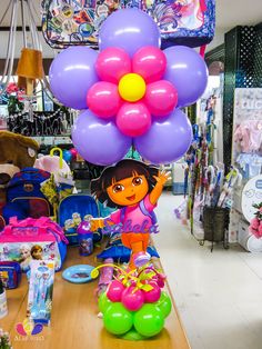 a table with balloons, toys and other items on it in a store display area