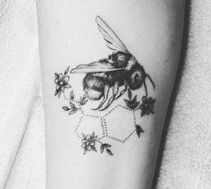 a black and white photo of a bee with flowers on it's side arm