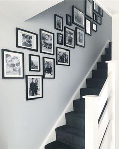 black and white photo frames on the wall next to stairs